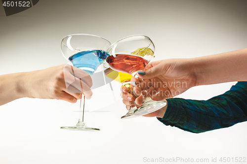 Image of The male and female hands with exotic cocktails