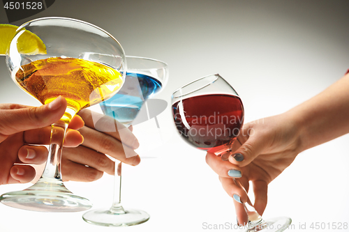 Image of The male and female hands with exotic cocktails