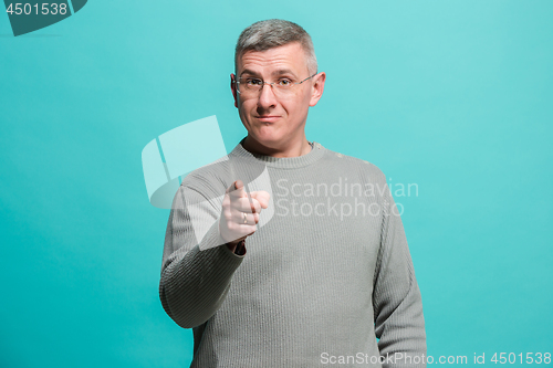 Image of The happy business man point you and want you, half length closeup portrait on blue background.