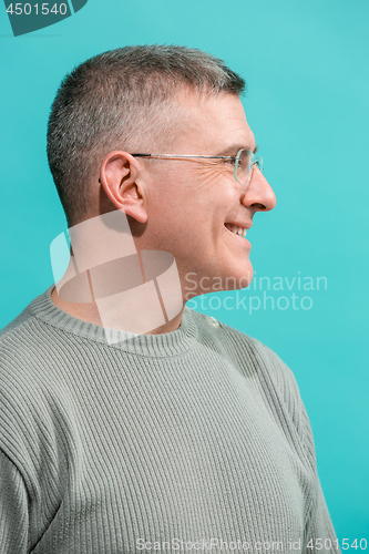 Image of The happy business man standing and smiling against blue background.