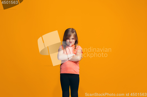 Image of Portrait of angry teen girl on a orange studio background