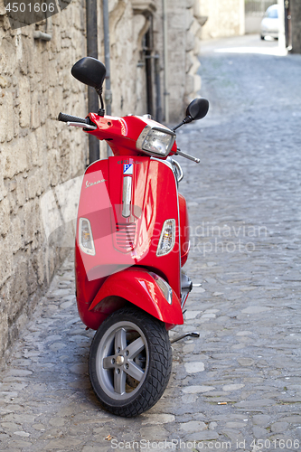 Image of Rome, Italy - March 31, 2019: Red Scooter Vespa parked on old st