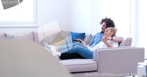 Image of Young couple on the sofa watching television