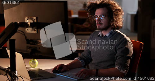 Image of man working on computer in dark office