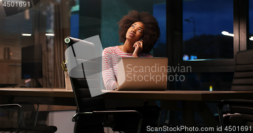 Image of black businesswoman using a laptop in night startup office