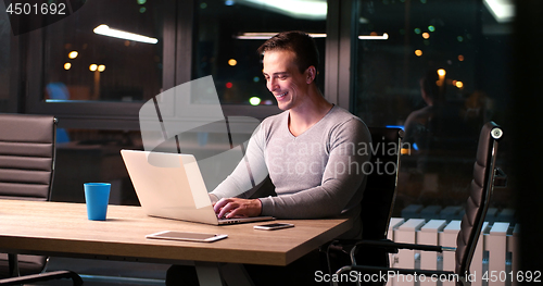 Image of man working on laptop in dark office