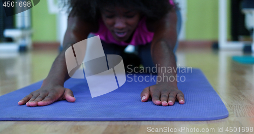 Image of back woman in a gym stretching and warming up