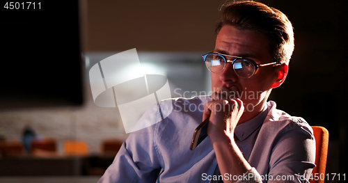 Image of man working on computer in dark office