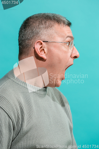 Image of The young attractive man looking suprised isolated on blue