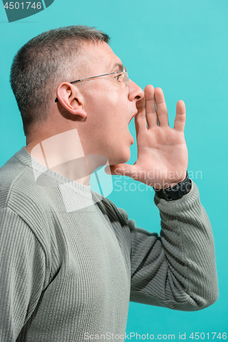 Image of Isolated on blue casual man shouting at studio