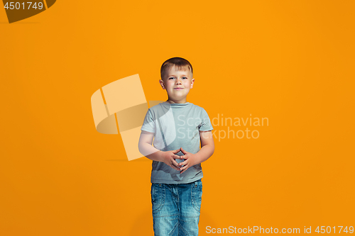 Image of The happy teen boy standing and smiling against orange background.