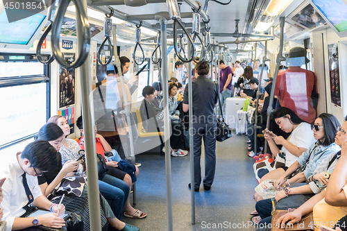 Image of Passenegers using their mobile phone devices while commuting by city metro in Bangkok, Thailand