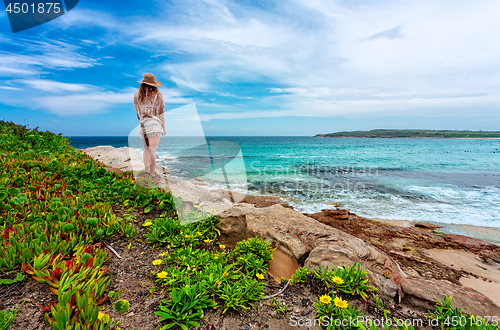 Image of Female admires beautiful Australian beach in summer