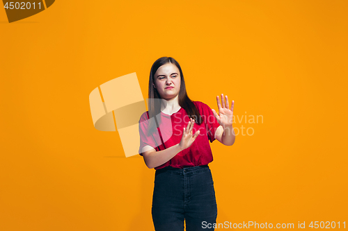 Image of Let me think. Doubtful pensive teen girl with thoughtful expression making choice against orange background