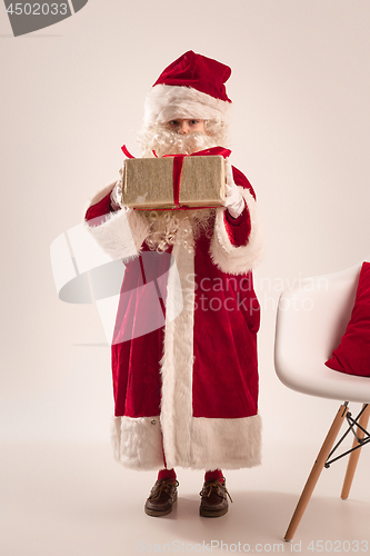 Image of The happy girl in santa claus costume with gift box at studio