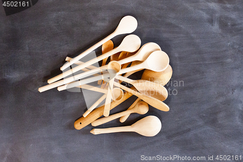 Image of Wooden spoons on blackboard background.