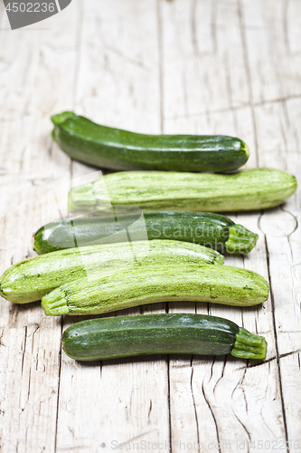 Image of Fresh green zucchini on wooden rustic table.
