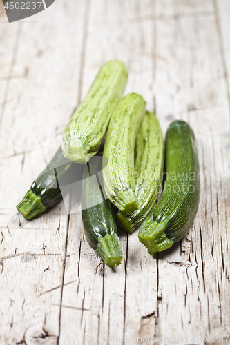 Image of Fresh green zucchini on wooden rustic table.