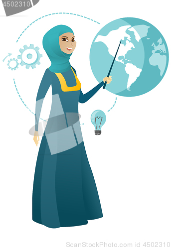Image of Muslim business woman pointing at a globe.