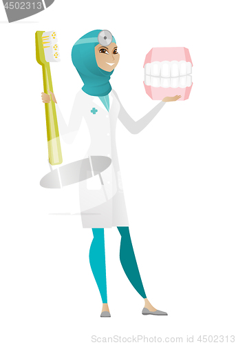 Image of Dentist with dental jaw model and toothbrush.