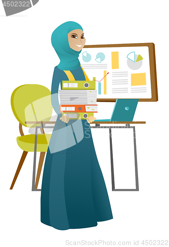 Image of Muslim business woman holding pile of folders.