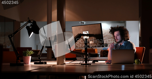 Image of man working on computer in dark office