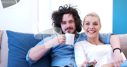 Image of Young couple on the sofa watching television