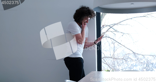 Image of young man using a tablet at home