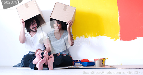 Image of young multiethnic couple playing with cardboard boxes