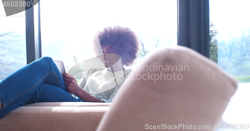 Image of african american woman at home using digital tablet