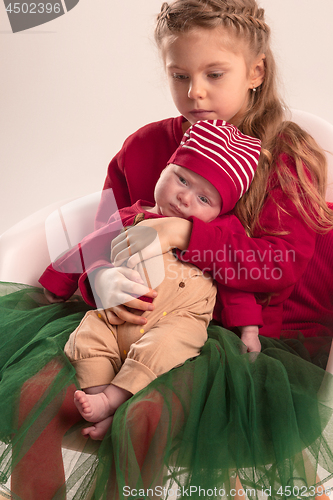 Image of Happy little teen girl holding his newborn baby little sister. Family love.