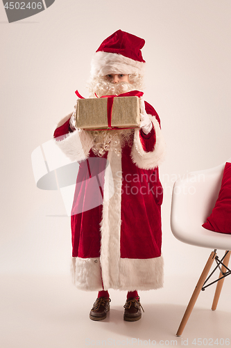 Image of The happy girl in santa claus costume with gift box at studio
