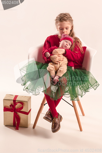 Image of Happy little teen girl holding his newborn baby little sister. Family love.