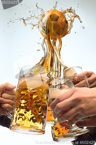 Image of The many male hands with mugs of beer toasting on studio white background. Sport, fan, bar, pub, celebration, soccer football concept.