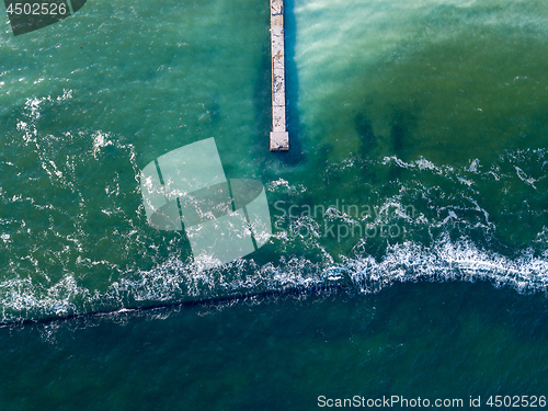 Image of Natural sea background with turquoise water. Top aerial view from drone to moles and jetty with foam waves. Copy space.