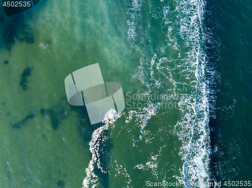 Image of Abstract turquoise sea water with white foam waves for natural background. Aerial top view from drone above ocean. Copy space.