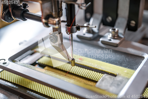 Image of Professional sewing machine close-up. Modern textile industry.