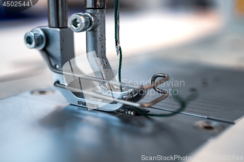 Image of Professional sewing machine close-up. Modern textile industry.