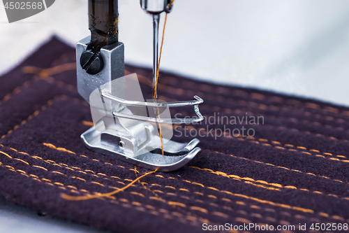 Image of Professional sewing machine close-up. Modern textile industry.