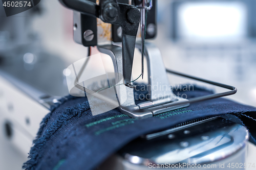 Image of Professional sewing machine close-up. Modern textile industry.