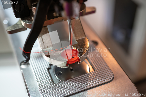 Image of Fastening sewing machine close-up. Modern textile industry.