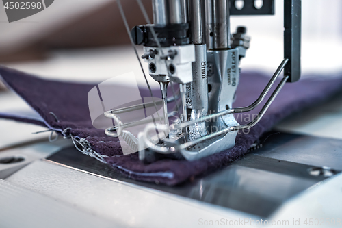 Image of Professional sewing machine close-up. Modern textile industry.
