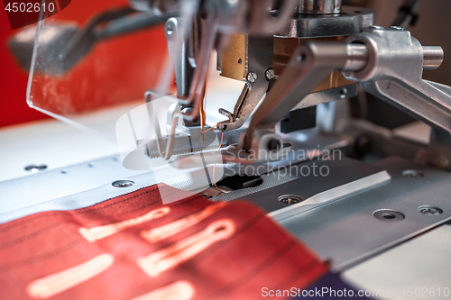 Image of Professional sewing machine close-up. Modern textile industry.