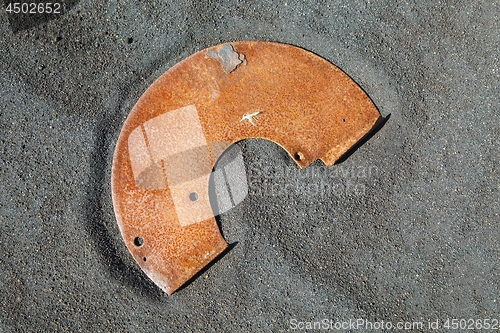 Image of Rusty metal junk on black sand