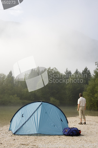 Image of Backpacker standing beside his tent