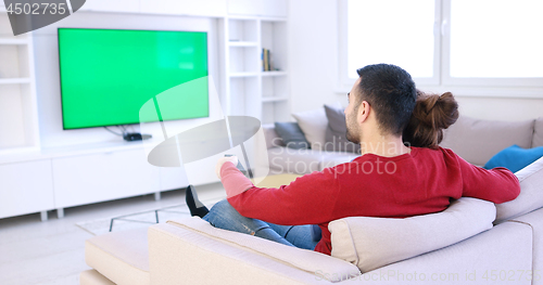 Image of Young couple on the sofa watching television