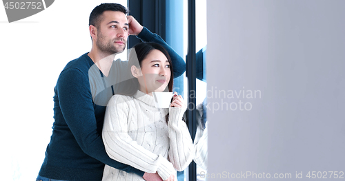 Image of multiethnic couple relaxing at modern home indoors