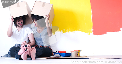 Image of young multiethnic couple playing with cardboard boxes