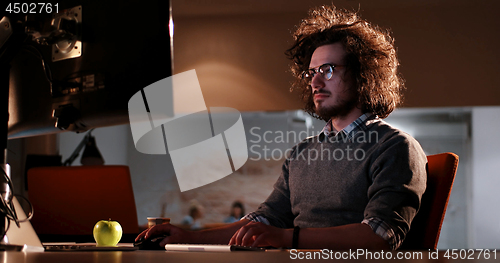 Image of man working on computer in dark office