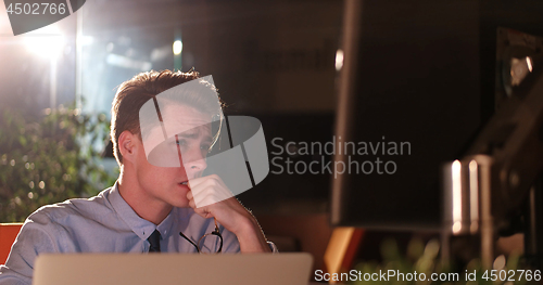 Image of man working on computer in dark office